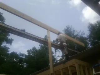 Carpenter setting a ridge beam over a new addition frame — Ice Dam Removal by Roofing Brothers in Yankton