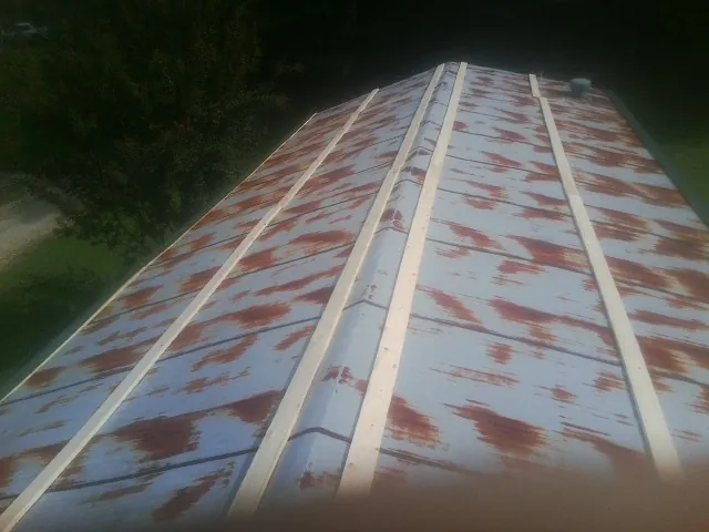Rusted metal roof panels with new wood purlins before replacement — Storm Damage Roof Repair in Yankton by Roofing Brothers