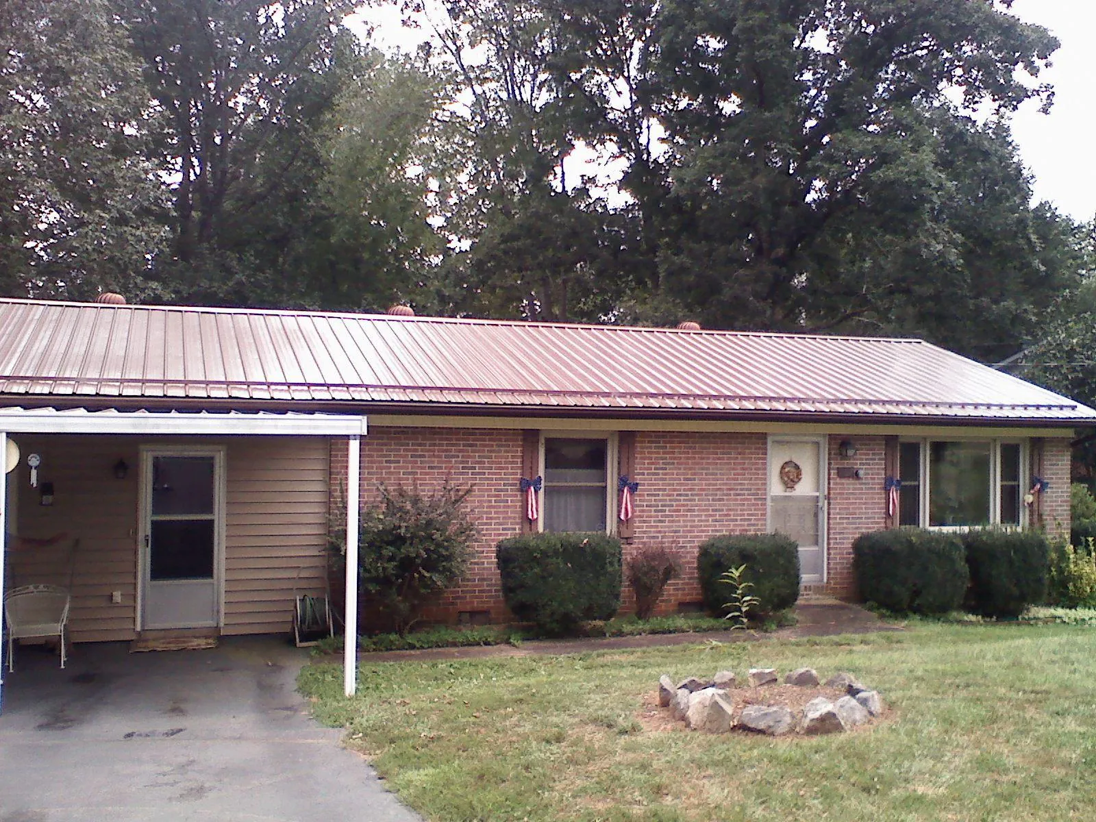Bronze metal roof and carport on a brick ranch home — Roof Repair work by our crew in Yankton