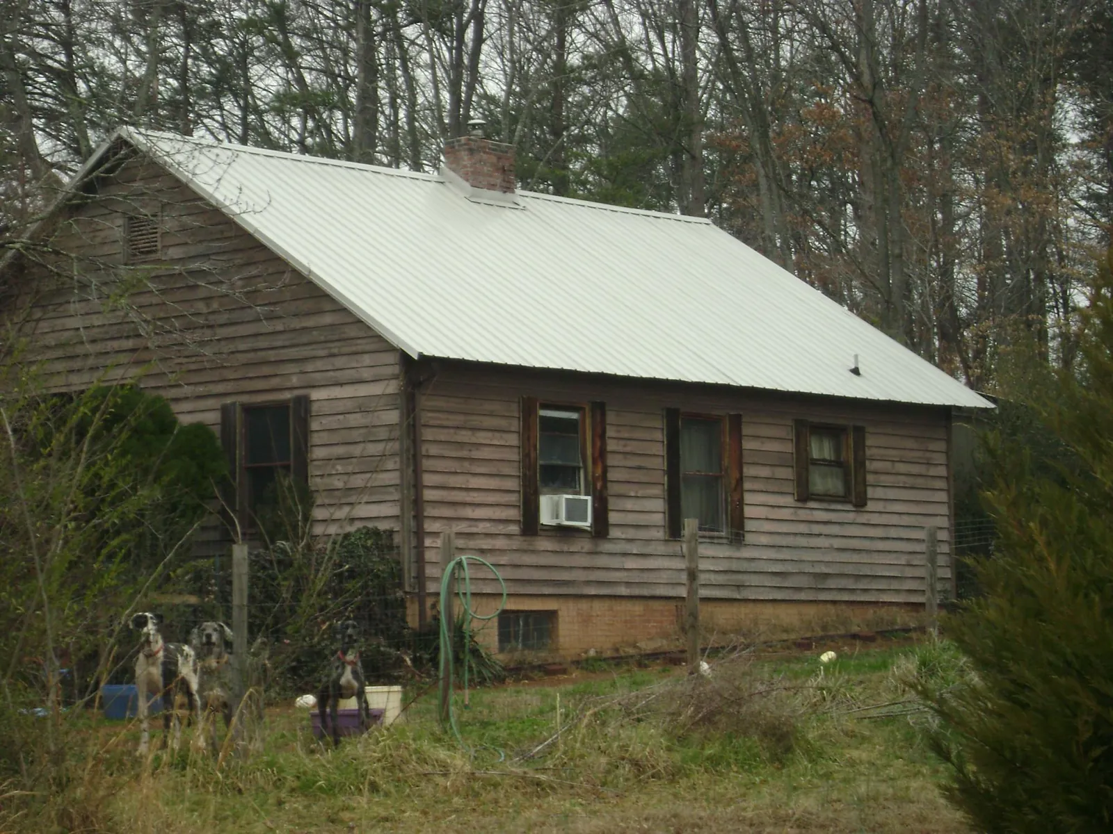 White metal roof on an old wood sided farmhouse, from a Metal Roof Installation job in Yankton